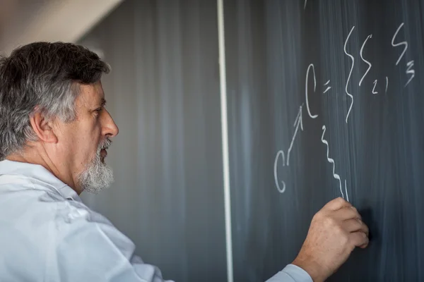 Seniorprofessor für Chemie schreibt auf der Tafel — Stockfoto