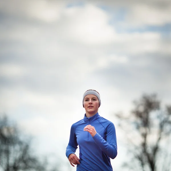 Donna che corre contro il cielo blu — Foto Stock