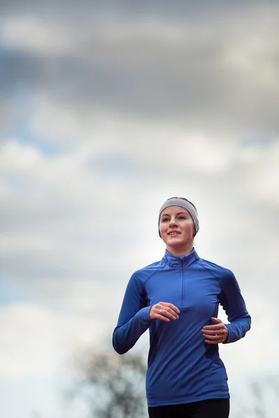 Woman running against against blue sky Royalty Free Stock Images