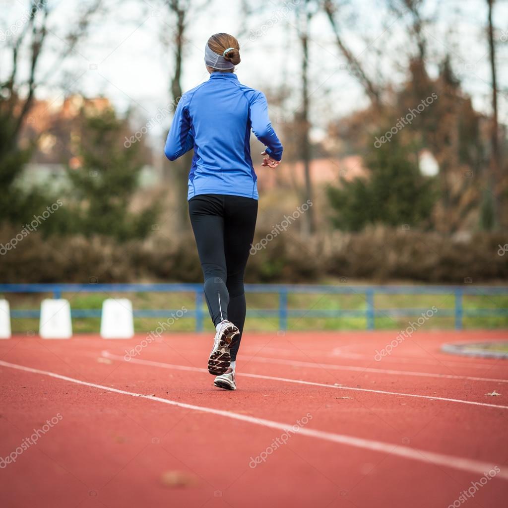 Woman running at a track and field stadium