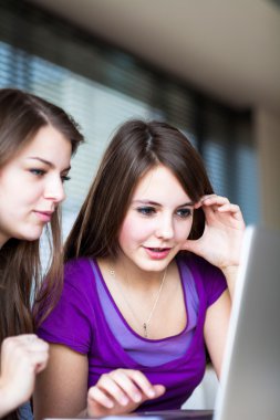 Üniversite öğrencileri sınıfta bir tablet bilgisayar kullanarak