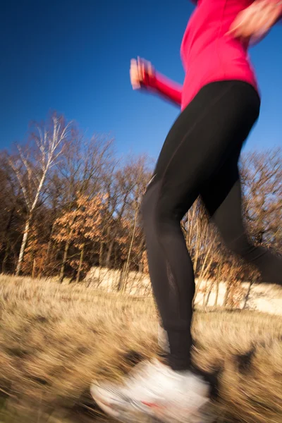 Женщина бежит на открытом воздухе в прекрасный солнечный зимний или осенний день — стоковое фото
