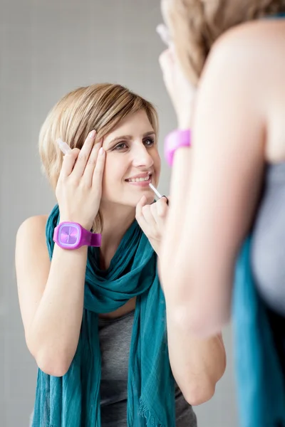 Frau trägt Lipgloss auf — Stockfoto