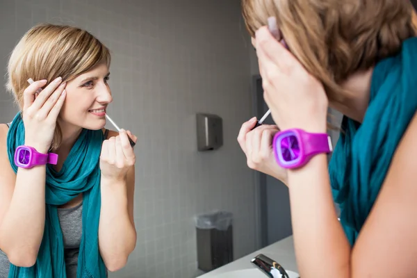 Frau trägt Lipgloss auf — Stockfoto