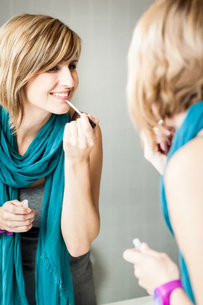 Mujer aplicando brillo labial —  Fotos de Stock