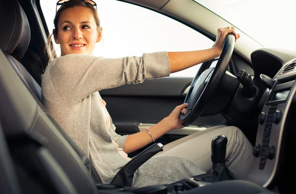 Mooie jonge vrouw haar nieuwe auto rijden — Stockfoto