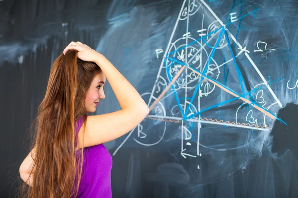 Jovem estudante universitário escrevendo no quadro negro — Fotografia de Stock