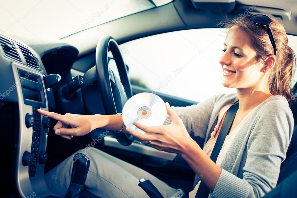 Female driver playing music in the car