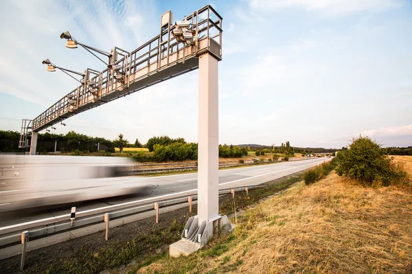 Vrachtwagen passeren een tol-poort op een snelweg — Stockfoto