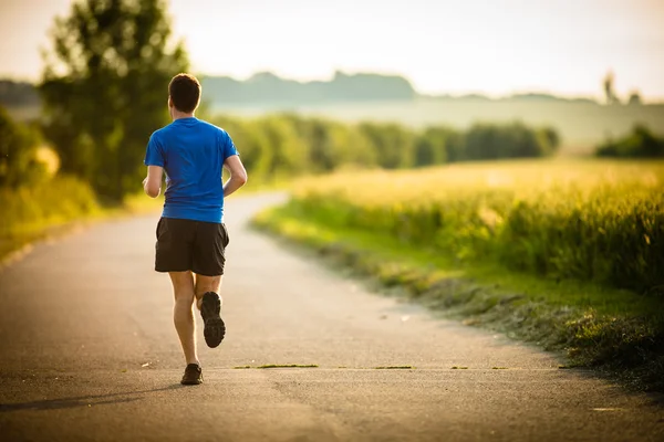 Atleta maschile, corridore che corre su strada — Foto Stock