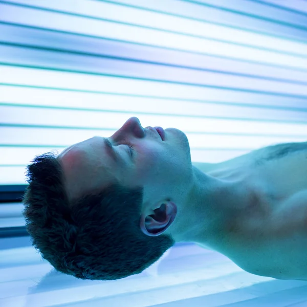 Homme relaxant pendant une séance de bronzage — Photo