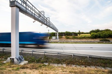 Truck passing through a toll gate on a highway clipart