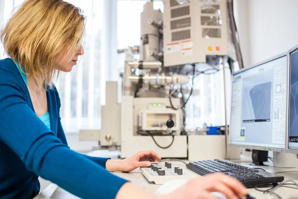 Female researcher using a microscope in a lab — Stock Photo, Image