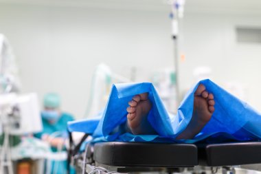 Feet of a patient ready  for a surgery in a surgery room clipart