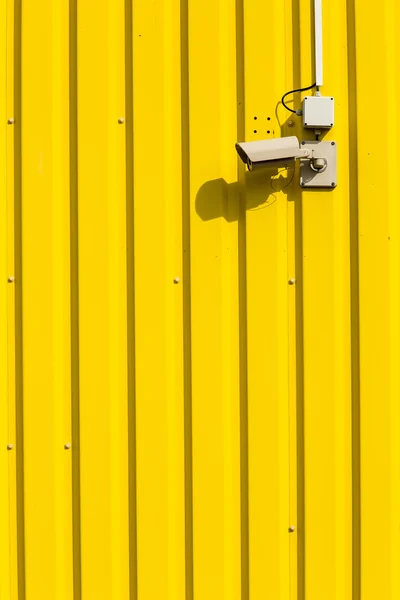 Cámara de seguridad en una pared amarilla — Foto de Stock