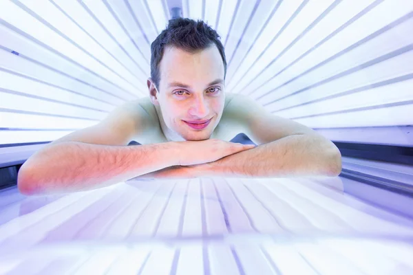 Homme relaxant pendant une séance de bronzage — Photo