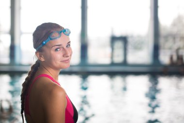 Bir kapalı yüzme havuzunda kadın yüzücü