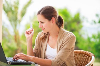 pretty young woman working on her computer clipart