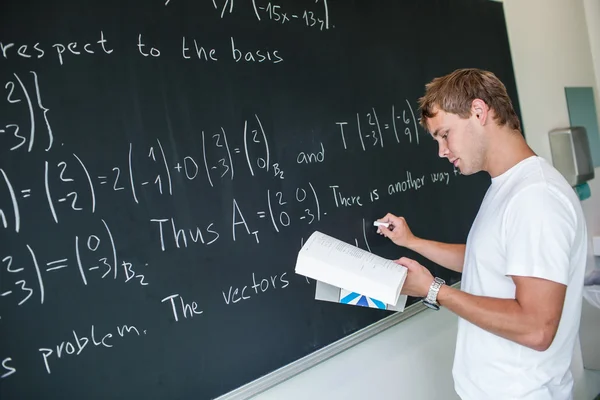 Estudante universitário bonito resolver um problema de matemática — Fotografia de Stock