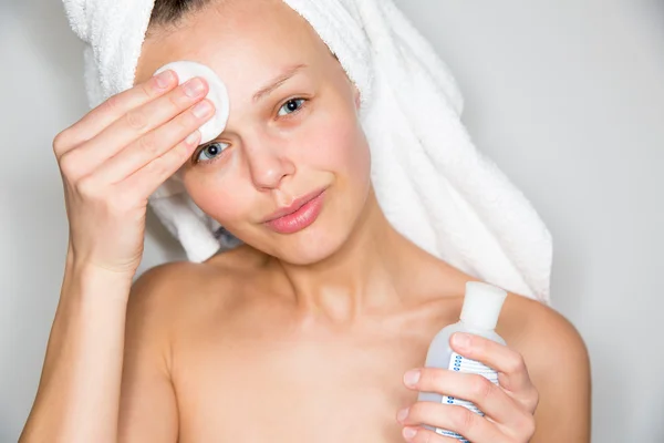 Brunette vrouw verwijderen van make-up van haar gezicht — Stockfoto