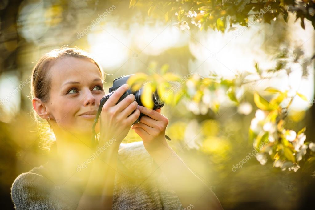 Pretty female amateur photographer taking photos