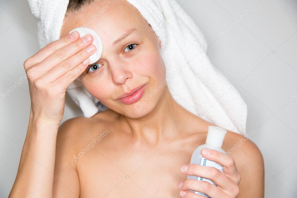 woman removing makeup from her face