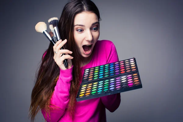 Niedliche Visagistin hält ihre riesige Palette von Farben und Händen — Stockfoto