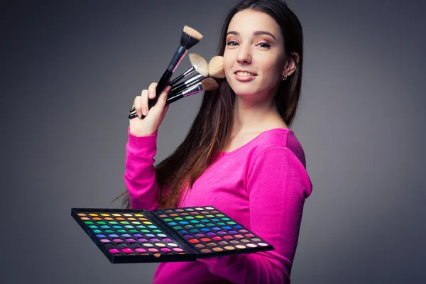 Cute make-up artist holding her vast palette of colors and hands — Stock Photo, Image