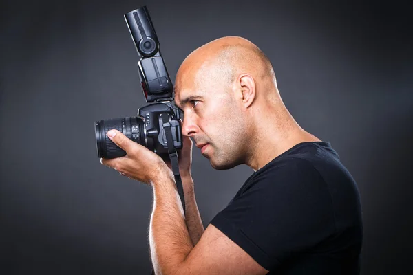 Jovem, fotógrafo masculino profissional em seu estúdio durante uma sessão de fotos — Fotografia de Stock