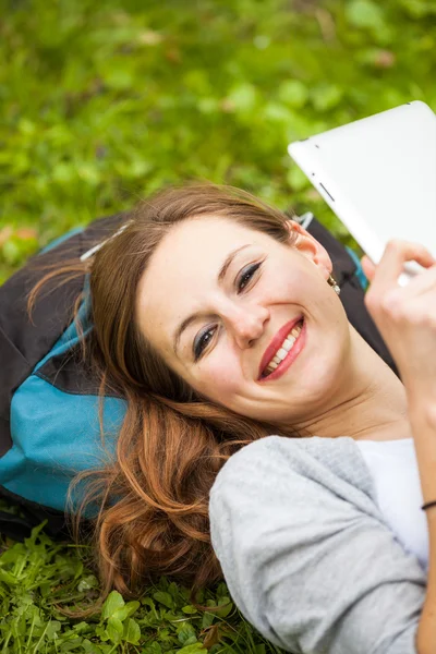 Junge Frau beim Entspannen im Freien mit ihrem Tablet-Computer — Stockfoto