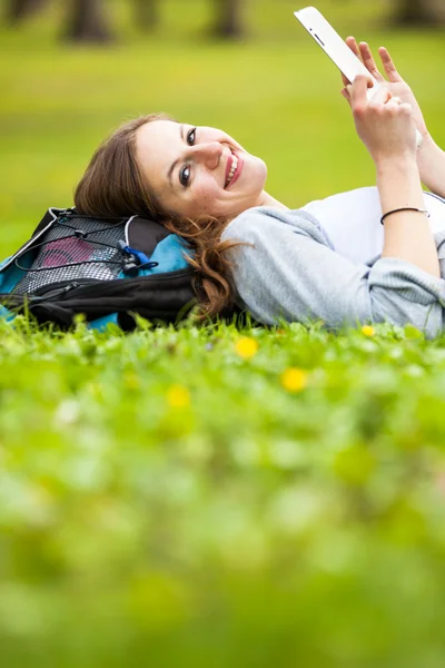 Jeune femme utilisant son ordinateur tablette tout en se relaxant à l'extérieur — Photo