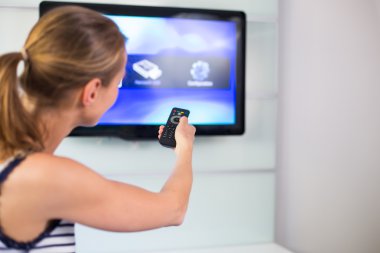 Genç kadın evde Tv izlerken