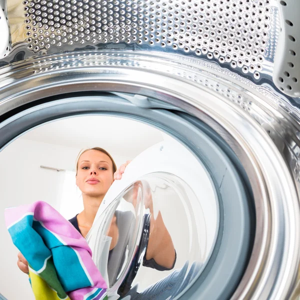 Trabalho doméstico: mulher jovem fazendo lavanderia (DOF rasa; cor tonificada i — Fotografia de Stock
