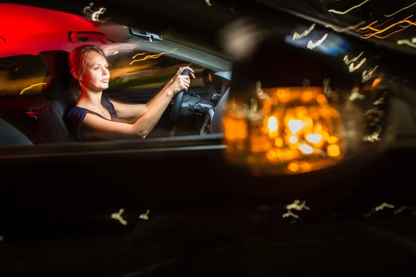 Besturen van een auto in de nacht - mooi, jonge vrouw rijden haar moderne — Stockfoto