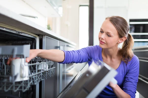 Domácí práce: mladá žena dává nádobí do myčky — Stock fotografie