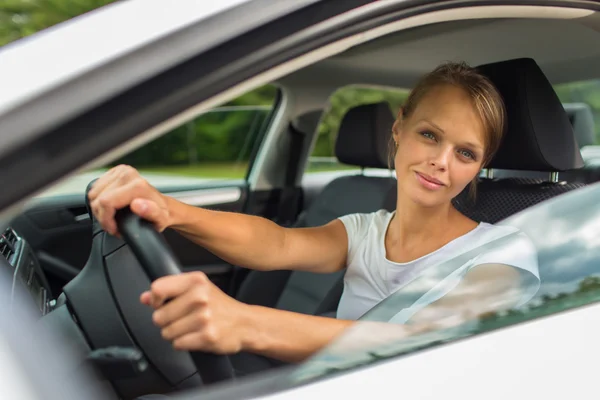 Young woman driving her car, on her way home from work — Stock Photo, Image