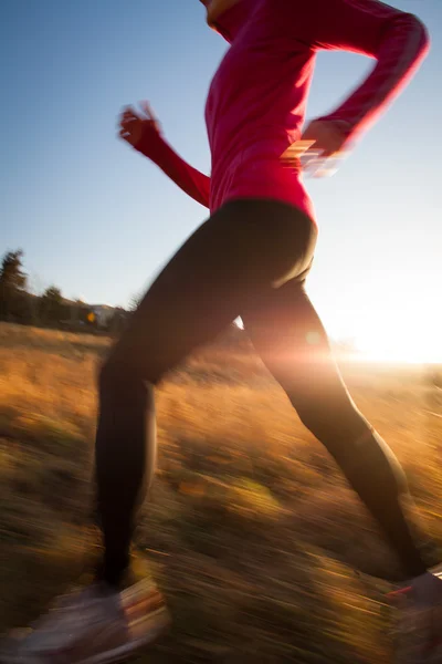 Junge Frau läuft an einem schönen, sonnigen Winter- / Herbsttag im Freien — Stockfoto