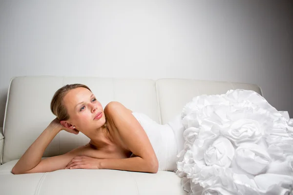 Beautiful bride lying on a sofa — Stock Photo, Image