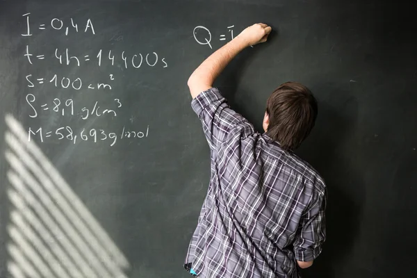 Студент коледжу вирішує математичну задачу під час уроку математики — стокове фото