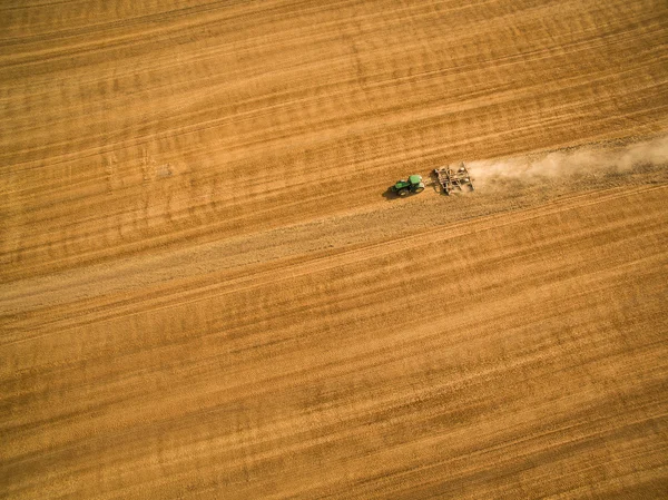 Luchtfoto van een trekker die na de oogst op een veld werkt — Stockfoto