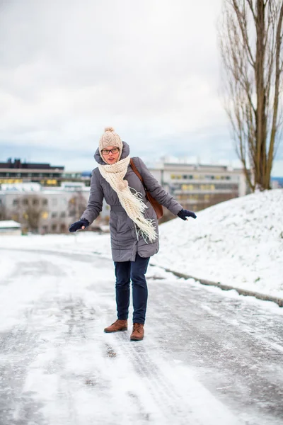 Csinos, fiatal nő birtoklás bajok gyaloglás-ra egy jeges — Stock Fotó