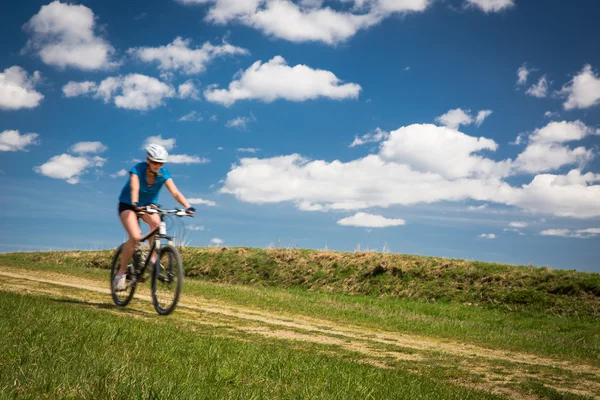 Bonito, jovem motociclista ao ar livre em sua bicicleta de montanha (movimento — Fotografia de Stock