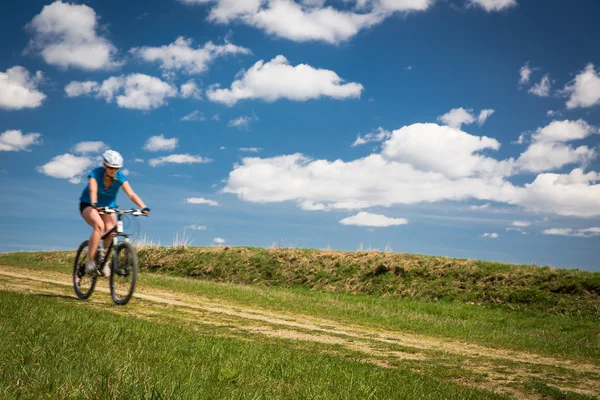 Guapa, joven motorista al aire libre en su bicicleta de montaña (movimiento — Foto de Stock