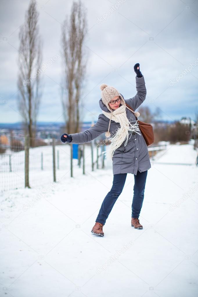Pretty, young woman having troubles walking on an icy