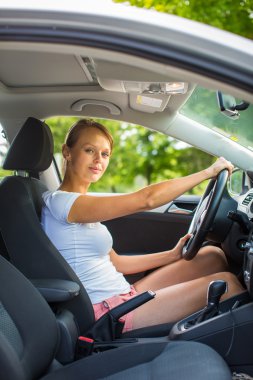 Arabasını süren genç bir kadın.