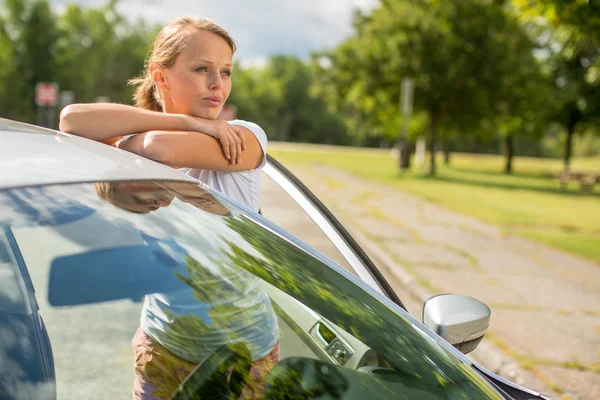 Mujer joven de pie junto a su nuevo coche — Foto de Stock