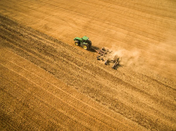 Vue aérienne d'un tracteur travaillant dans un champ après la récolte — Photo