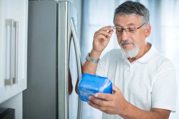 Is this still fine? Senior man in his kitchen by the fridge — Stock Photo, Image