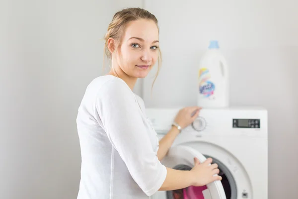 Hushållsarbete: ung kvinna gör tvätt — Stockfoto