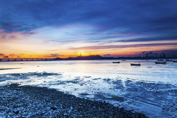 Tramonto costa con un ponte che collega lato opposto — Foto Stock